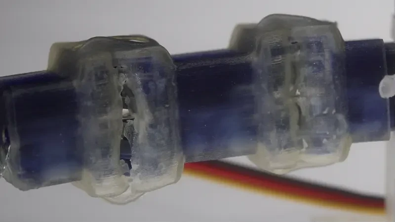 Close-up of a printed finger with dark rigid segments and translucent flexible connections